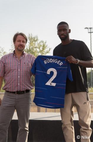 Der ehemalige Schüler Antonio Rüdiger überreicht der Schule ein Trikot